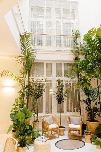 a room filled with lots of plants and chairs at Plaza Mina Suites - Adults Recommended by Luxury Suites Cadiz in Cádiz