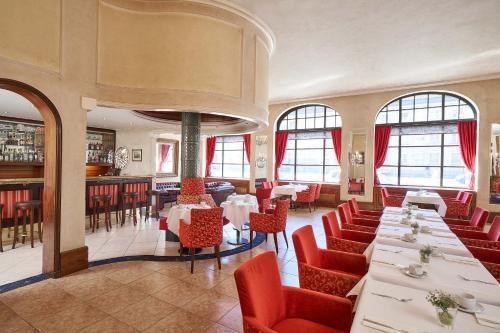a restaurant with white tables and red chairs at Hotel Monopol - Central Station in Frankfurt/Main