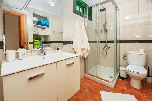 uma casa de banho com um chuveiro, um lavatório e um WC. em Lanzahost Cucharas Dreams em Costa Teguise