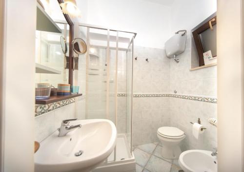 Baño blanco con lavabo y aseo en Il Sorgituro - Agriturismo, en Postiglione