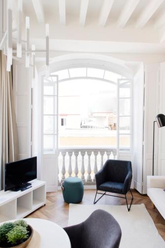 a living room with a couch and a chair at Plaza Mina Suites - Adults Recommended by Luxury Suites Cadiz in Cádiz