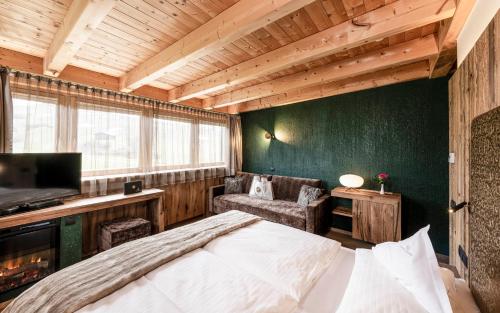 a bedroom with a large bed and a green wall at Hotel Santner Alpine Sport & Relax in Alpe di Siusi