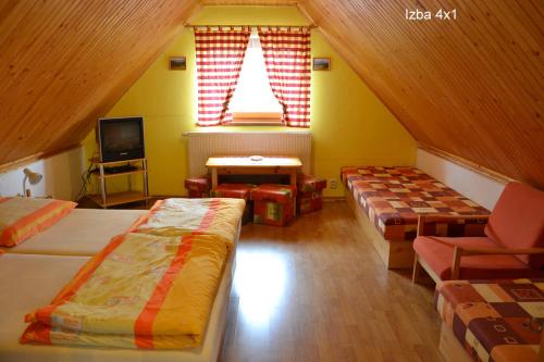 a attic room with three beds and a window at Privat Matej in Smrečany