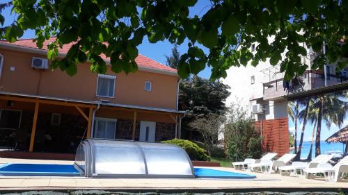 a pool in front of a house with a metal structure at Király Apartman in Fonyód