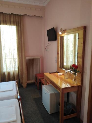 a bathroom with a wooden desk and a mirror at Hotel Faraggi in Kleidonia