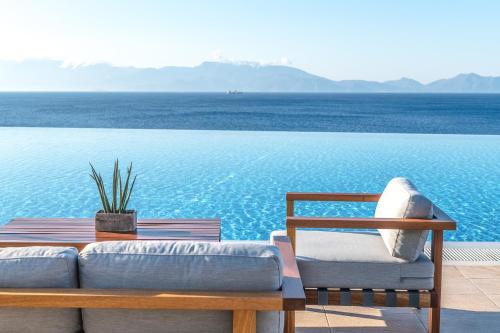 a couch sitting on a table next to the water at Michelangelo Resort & Spa in Agios Fokas