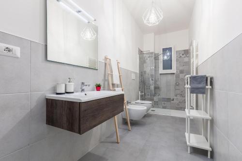 La salle de bains blanche est pourvue d'un lavabo et de toilettes. dans l'établissement RobertONE Guest House, à Bari