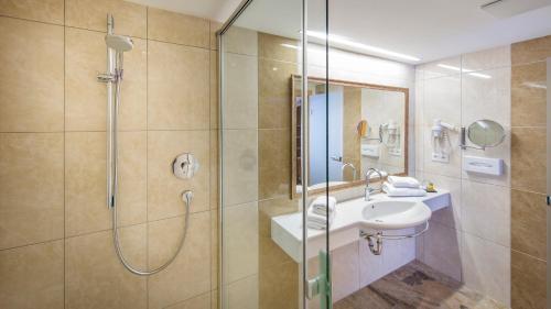 a bathroom with a shower and a sink at Huber Hotel Tramserhof in Landeck