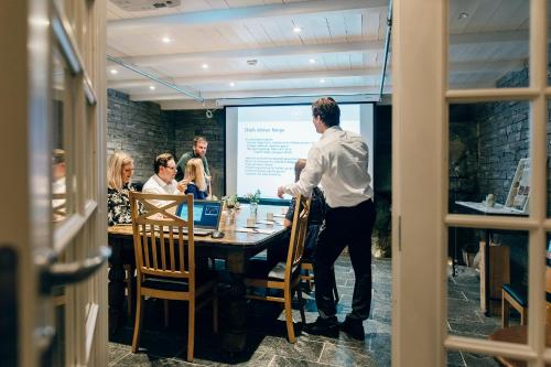 a man standing at a table in front of a presentation at Haaheim Gaard in Uggdal