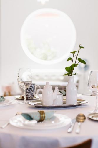 a white table with plates and glasses and a tea set at Hangers in Turda