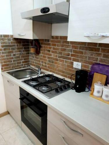 a kitchen with a stove and a brick wall at La Terrazza sul Tempio in Brindisi
