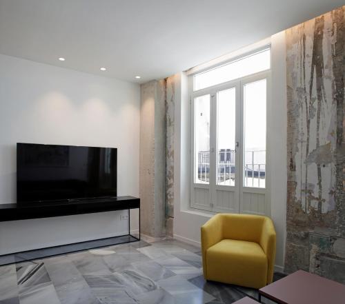 a living room with a television and a yellow chair at Fetén in Valencia
