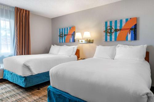 a hotel room with two beds and a window at MainStay Suites Emporia in Emporia