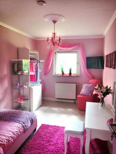 a pink room with a bed and a table and a window at Lighane's Studio with Sailor Moon Room in Nürnberg