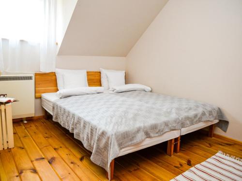 a bedroom with a large bed with wooden floors at tuŻur domki nad potokiem in Osie