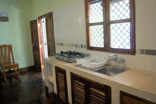 uma cozinha com um lavatório e um fogão em Luciano & Grace Apartments em Watamu
