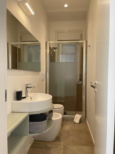 een badkamer met een wastafel, een toilet en een douche bij La vista sul porto in Marina di Ragusa