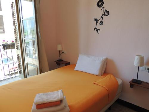 1 dormitorio con 1 cama con colcha de color naranja en Fonda Can Fasersia, en La Pobla de Segur