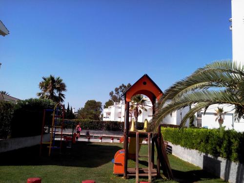 a playground with a swing set in a yard at Venecia Apartments in Port d'Alcudia