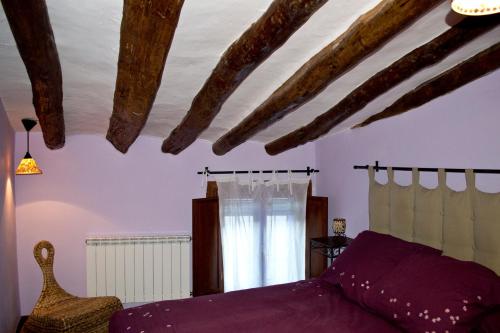 a bedroom with a purple bed and a window at Casa Rural Los Lilos in Gotor