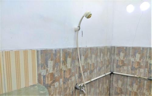una doccia con tubo fissato a un muro di Kendang Kempul Hostel a Dadapan