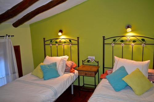 two beds in a room with green walls at Casa Rural Los Lilos in Gotor