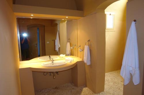 baño con lavabo y espejo grande en The Oasis, en Abu Dabab