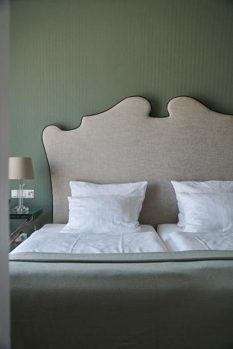 a large bed with white sheets and pillows at Hotel Monopol - Central Station in Frankfurt/Main