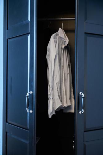 a white shirt is hanging in a blue cabinet at Hotel Monopol - Central Station in Frankfurt/Main