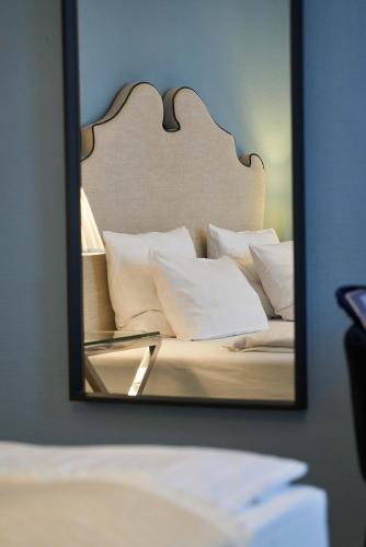 a mirror reflection of a bed with white pillows at Hotel Monopol - Central Station in Frankfurt/Main