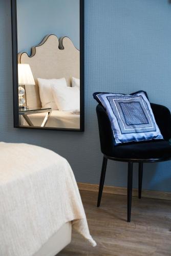 a bedroom with a mirror and a chair and a bed at Hotel Monopol - Central Station in Frankfurt/Main