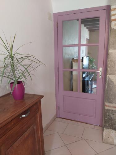 a purple door in a room with a potted plant at Ô Nature chéris mes voeux avant qu'ils s'enfuient in Francescas