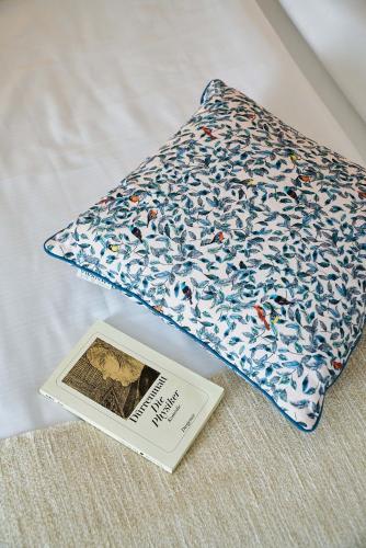 a book sitting on a bed next to a pillow at Hotel Monopol - Central Station in Frankfurt/Main