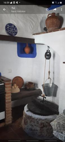 a room with a fireplace in a room with a bed at Casa rural El Patio con chimenea, barbacoa, piscina, patios exteriores para sus mascotas de manera gratuita in Benadalid