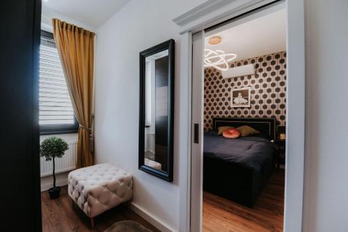 a bedroom with a bed and a mirror at Apartmány Evia clinic in Levice