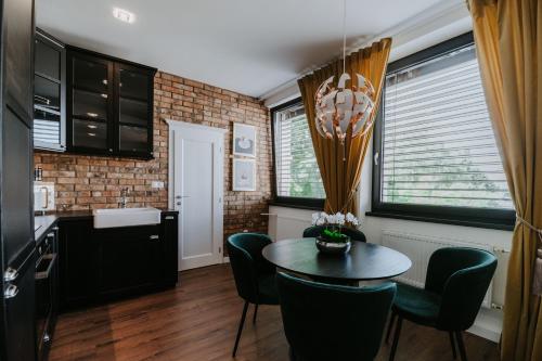 a kitchen and dining room with a table and chairs at Apartmány Evia clinic in Levice