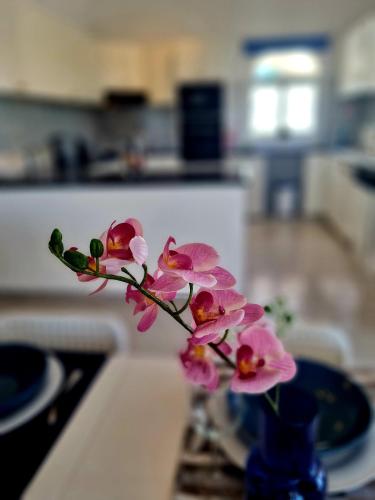 a vase with pink flowers sitting on a table at Villa Elysium, 3 bedrooms, pool, sea view & wifi in Tala