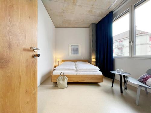 a bedroom with a bed and a desk at Guesthouse Kalkbreite in Zurich