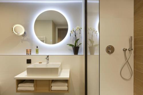 a bathroom with a sink and a mirror at Citadines Eurometropole Strasbourg in Strasbourg