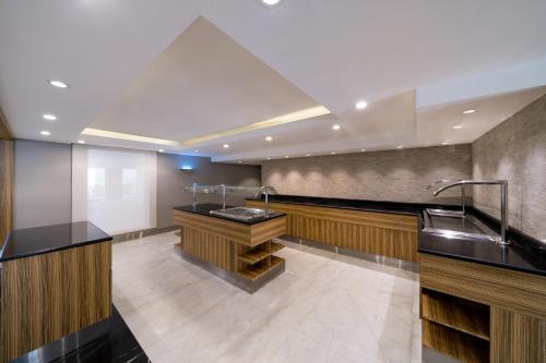 a kitchen with black counter tops and a sink at SAS Residence & Hotel Dhahran in Al Khobar