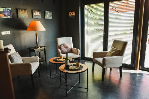 een woonkamer met stoelen, een tafel en een lamp bij SaunaPark SPA in Łowyń