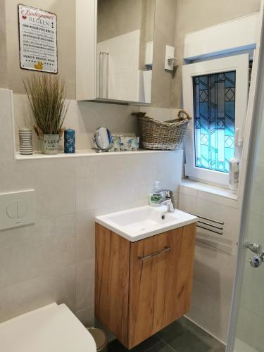 a bathroom with a sink and a toilet and a window at Casa Auszeit in Oranienburg