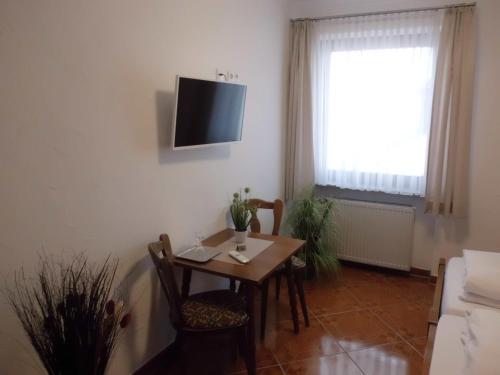 una sala da pranzo con tavolo e TV a parete di Hotel Restaurant Zur Pfanne a Coblenza