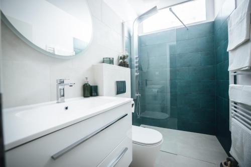 uma casa de banho com um lavatório, um WC e um chuveiro em Élmény Balaton Hotel em Alsóörs