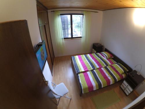 Kleines Zimmer mit einem Bett und einem Fenster in der Unterkunft Dramalj apartman 4+1 in Dramalj