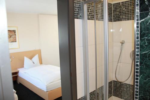 Schlafzimmer mit Dusche und Bett in der Unterkunft Hotel Hübler in Frankfurt am Main