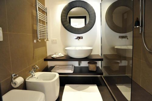 W łazience znajduje się umywalka, toaleta i lustro. w obiekcie Opera 11 r&b w mieście Parma