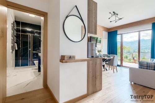 a kitchen and living room with a mirror on the wall at Tatra Resort & SPA in Kościelisko