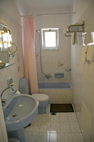 a bathroom with a tub and a toilet and a sink at Elite Apartments in Kos