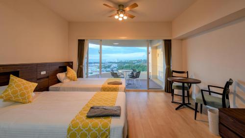 ein Hotelzimmer mit 2 Betten und einem Balkon in der Unterkunft Hotel Sunset Hill in Onna